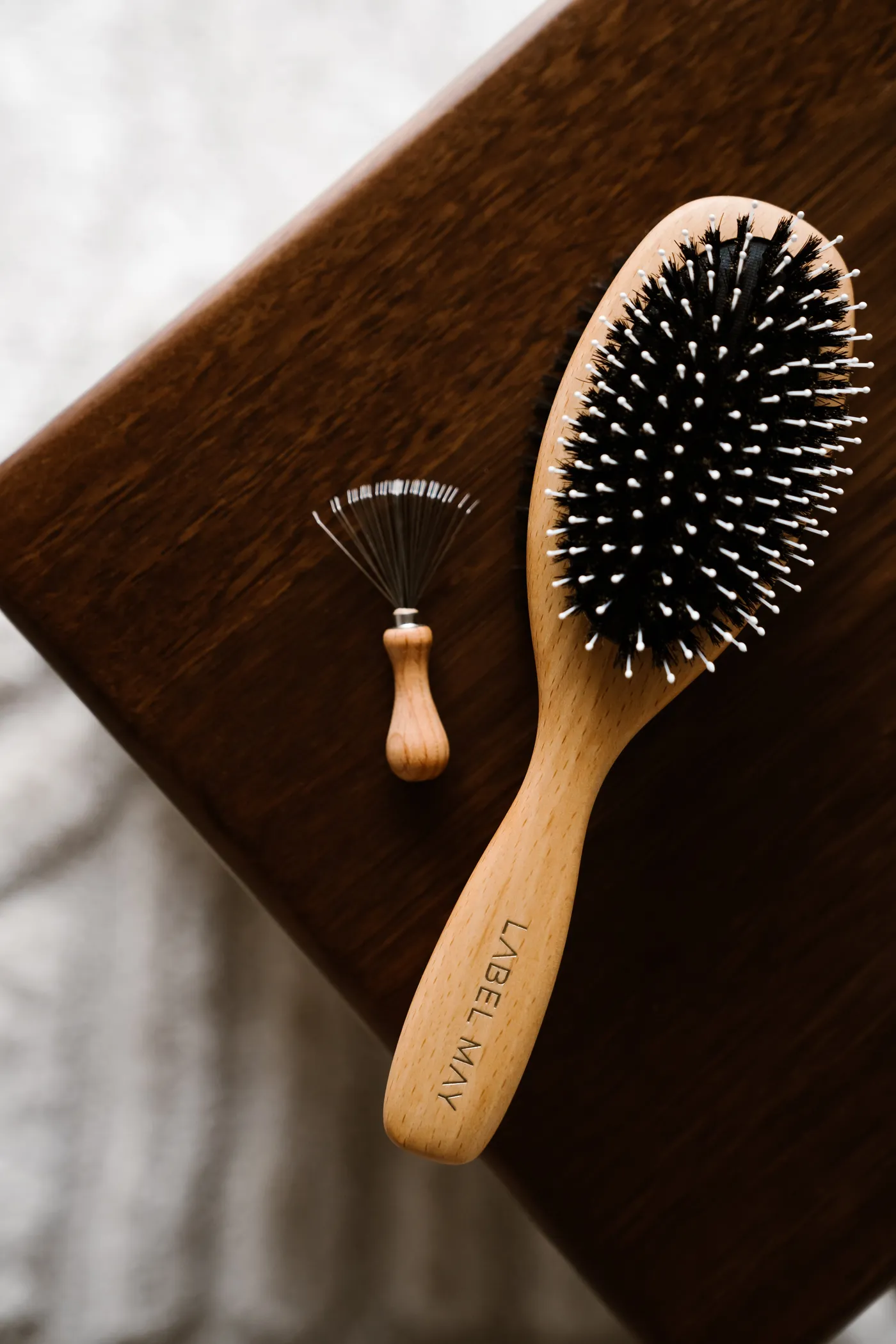 The brush and cleaning tool on dark wood